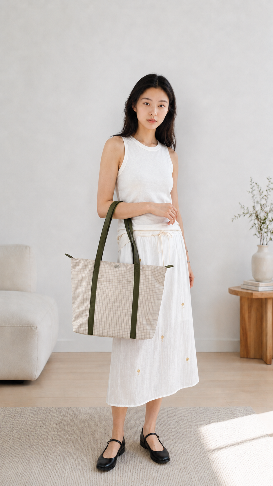 Woman carrying a beige preppy laptop tote over her shoulder