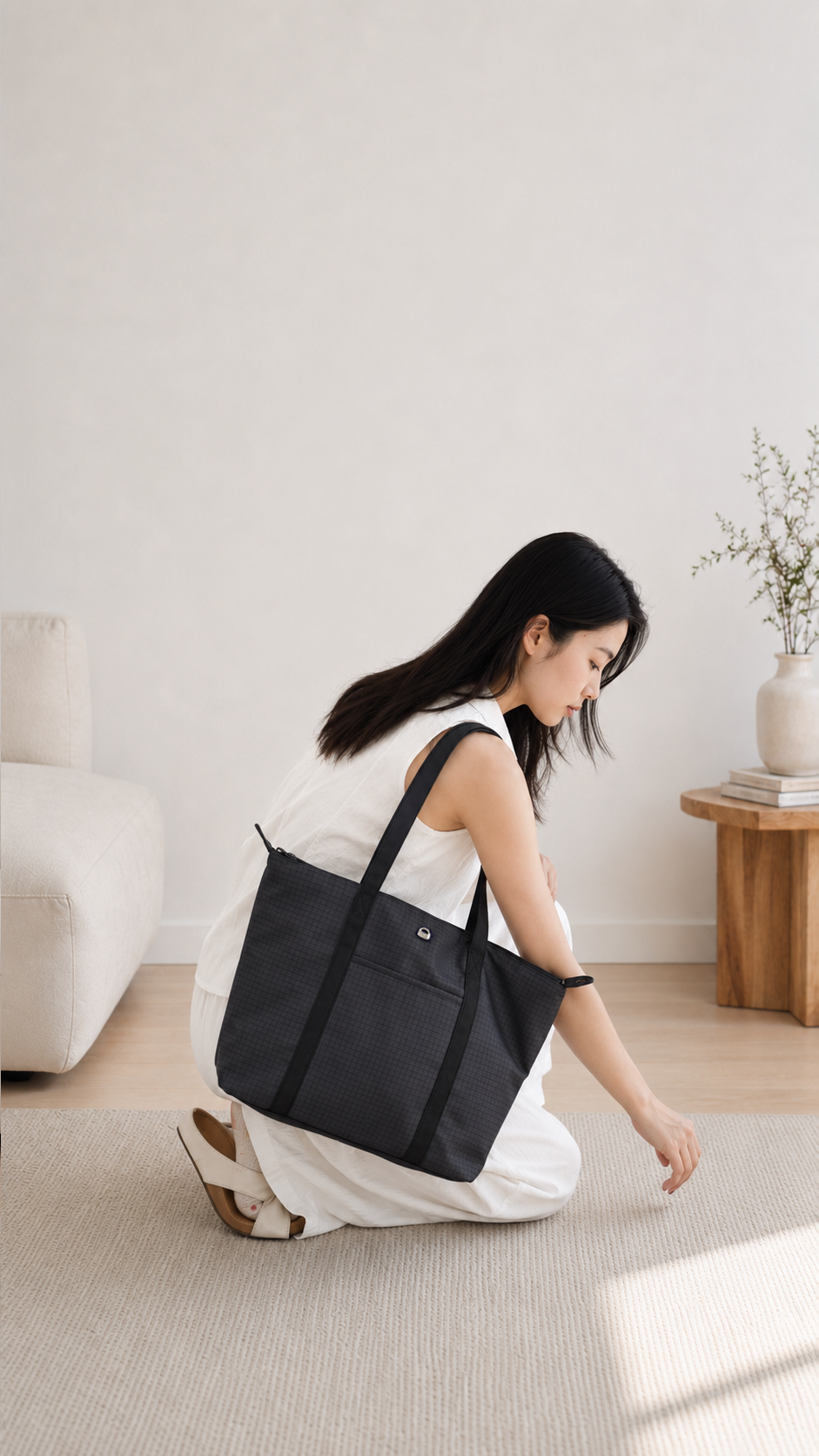 Woman reaching into a carbon black 14-inch laptop tote bag