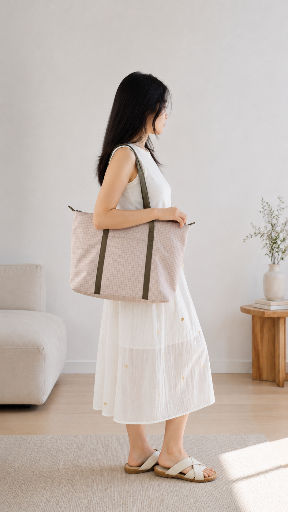 Woman carrying a beige preppy laptop tote over her shoulder