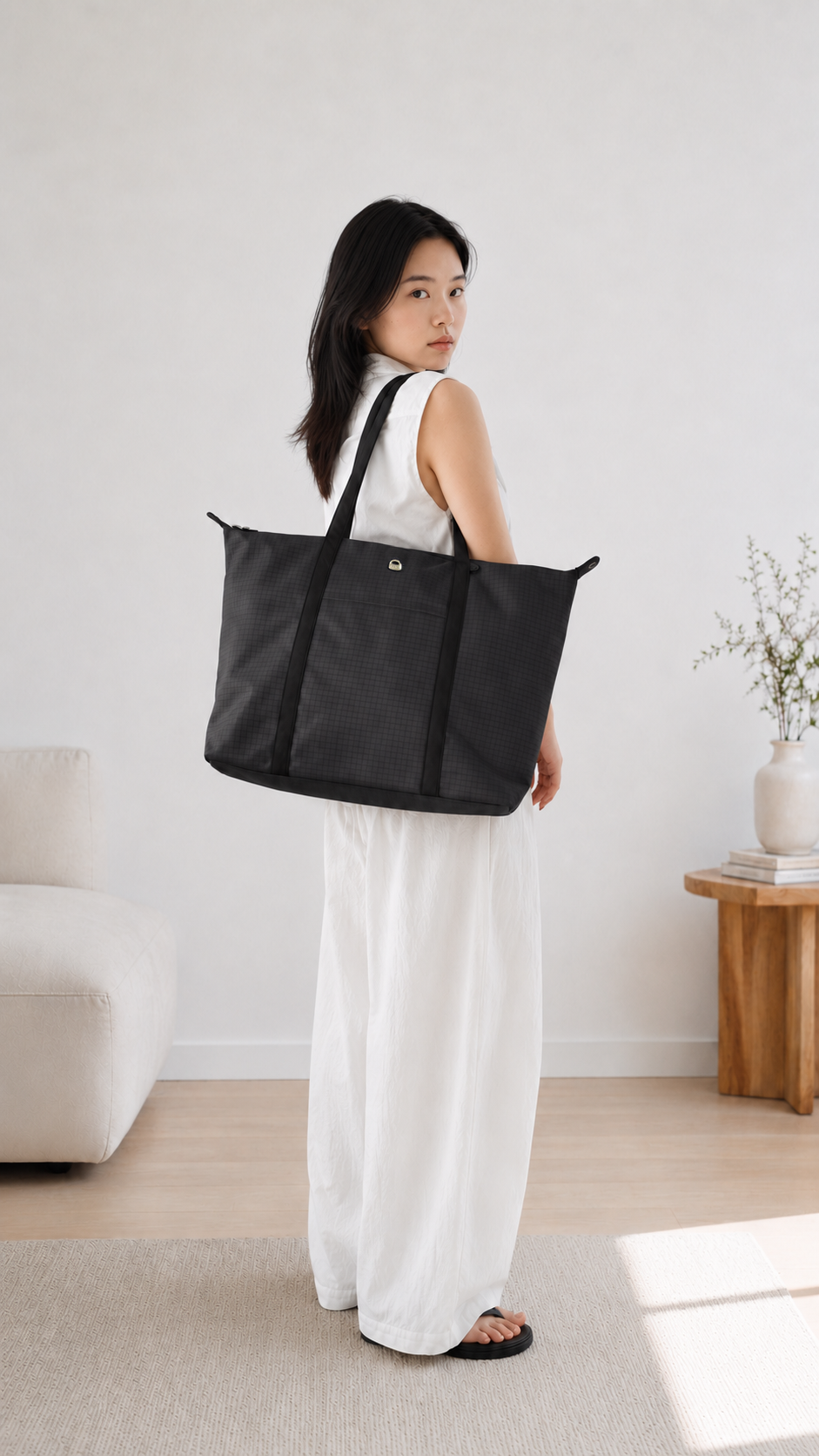Woman wearing a carbon black 16-inch laptop tote bag