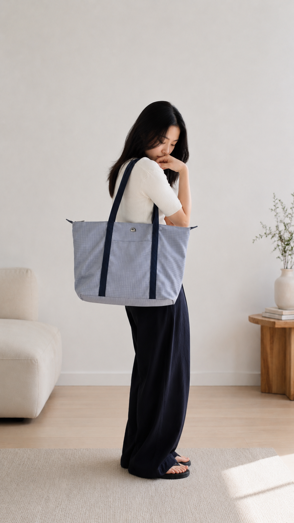 Woman wearing a light blue preppy laptop tote over her shoulder