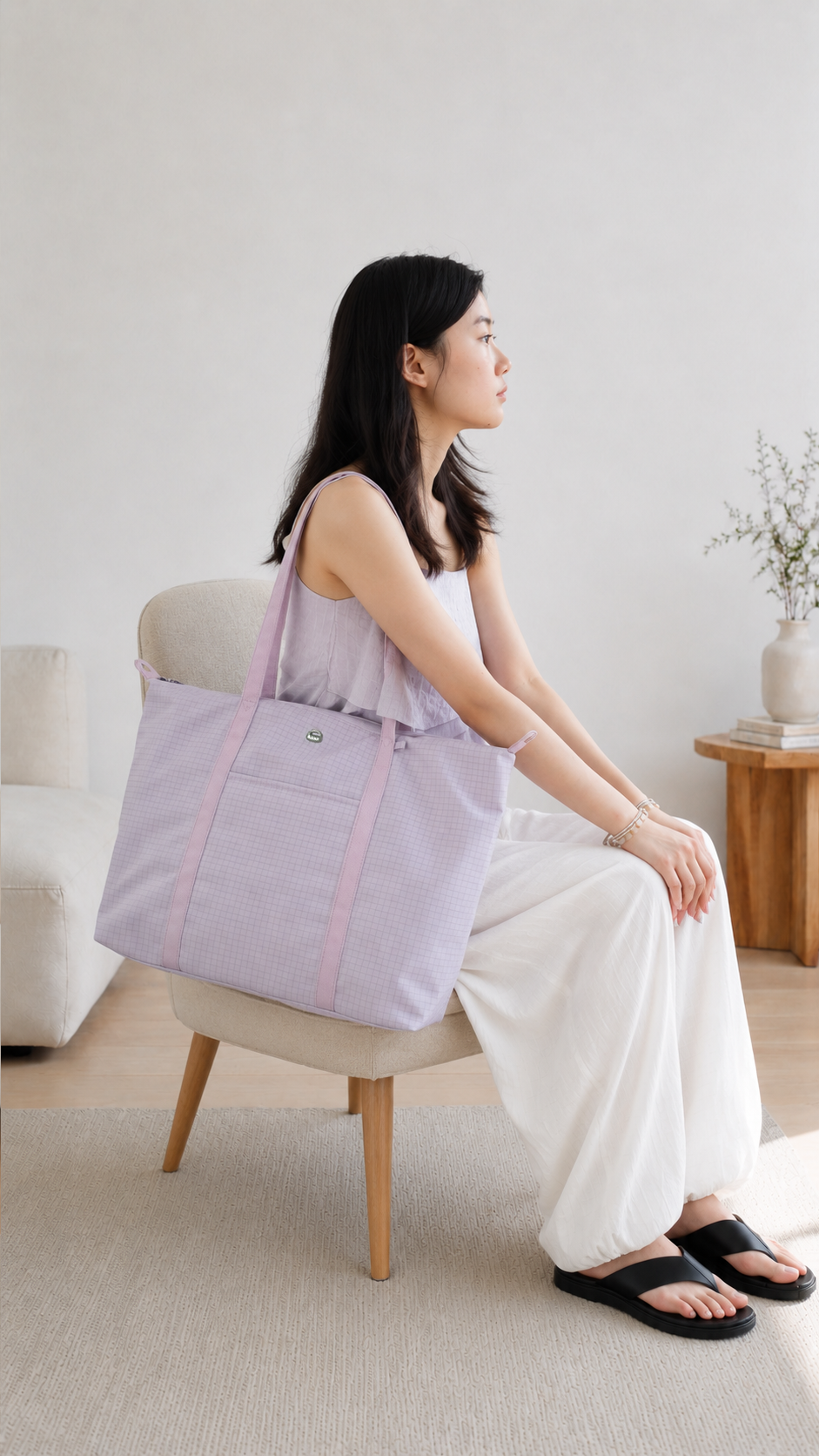 Woman seated with a light purple water-resistant laptop tote