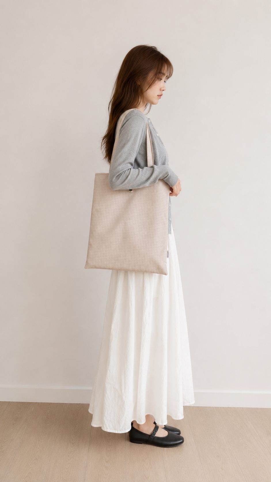 Woman wearing a beige vertical laptop tote over her shoulder