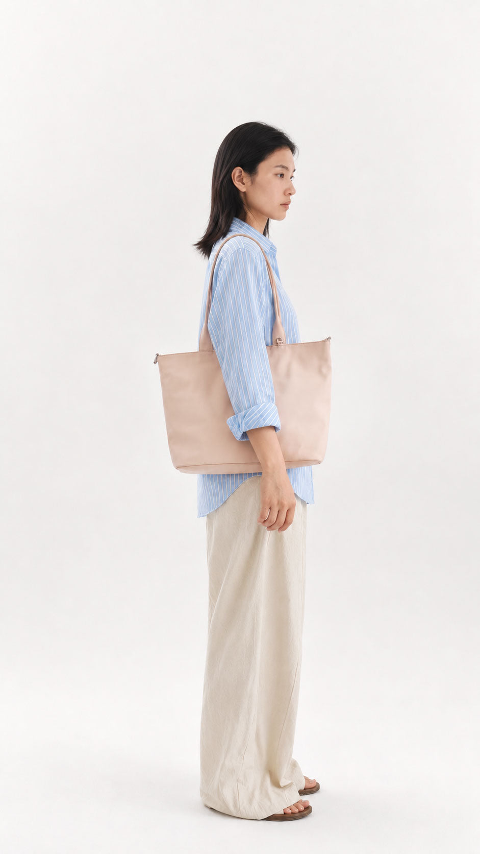 Woman carrying a champagne 16-inch laptop tote bag