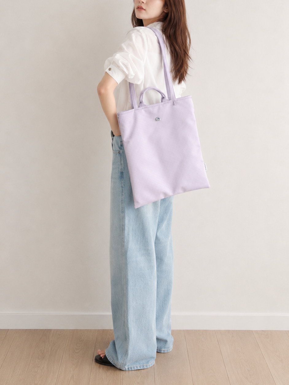 Woman wearing a light purple vertical laptop bag over her shoulder
