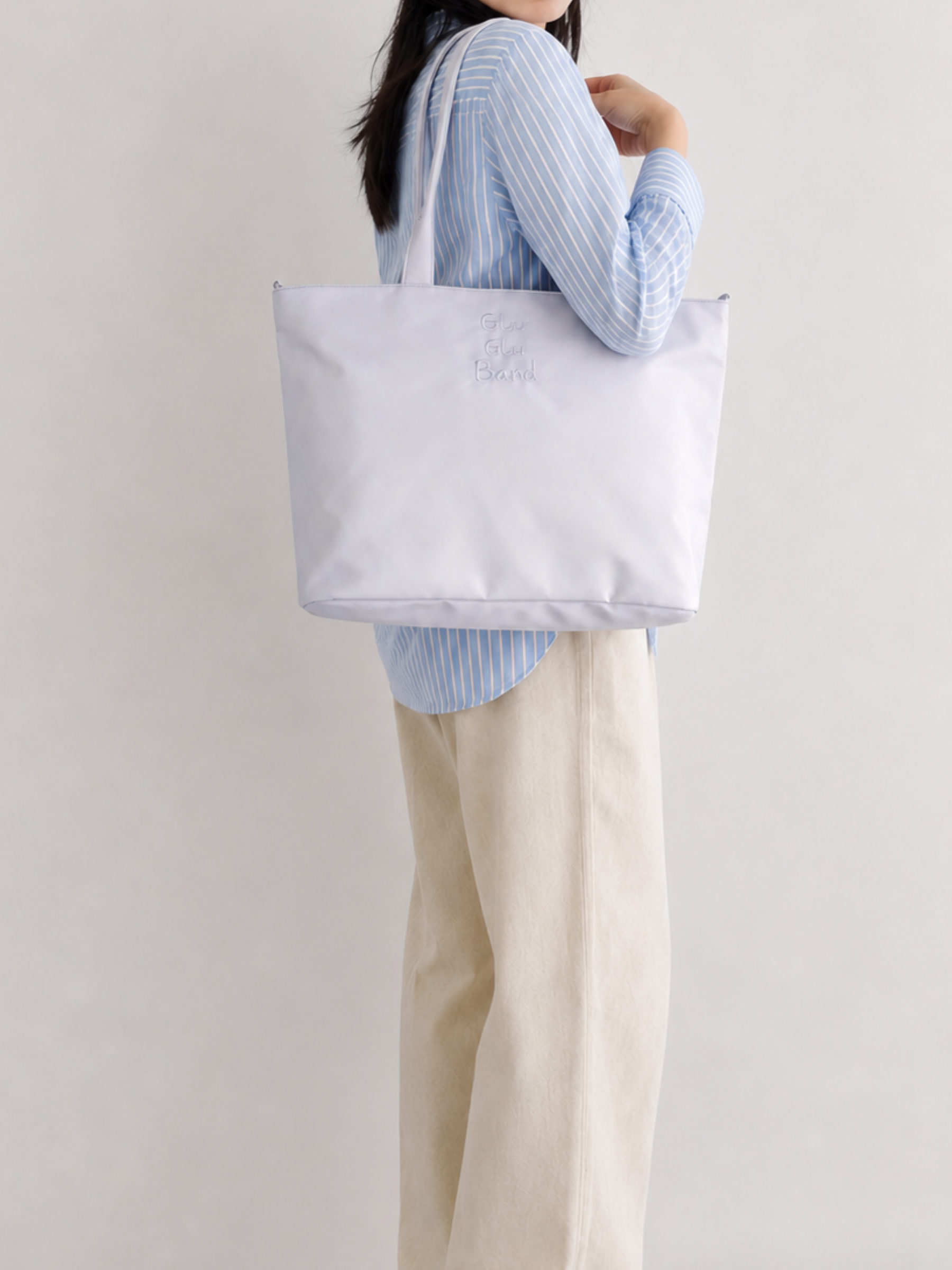 Woman wearing a pale blue-purple 16-inch laptop tote
