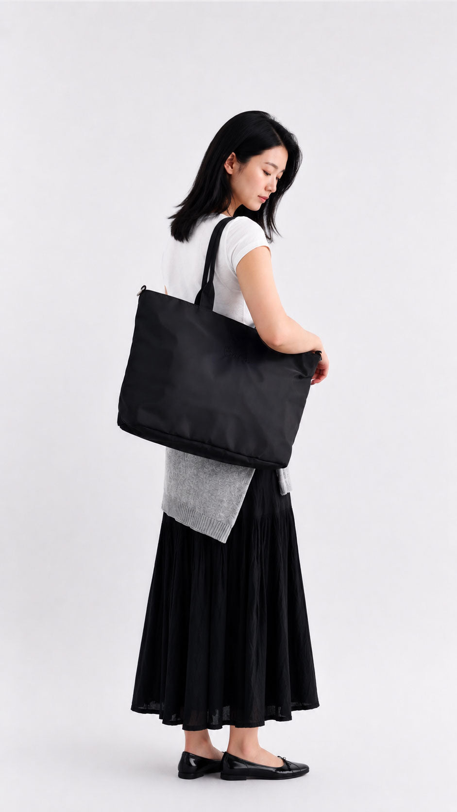 Woman carrying a carbon black laptop work tote over her shoulder
