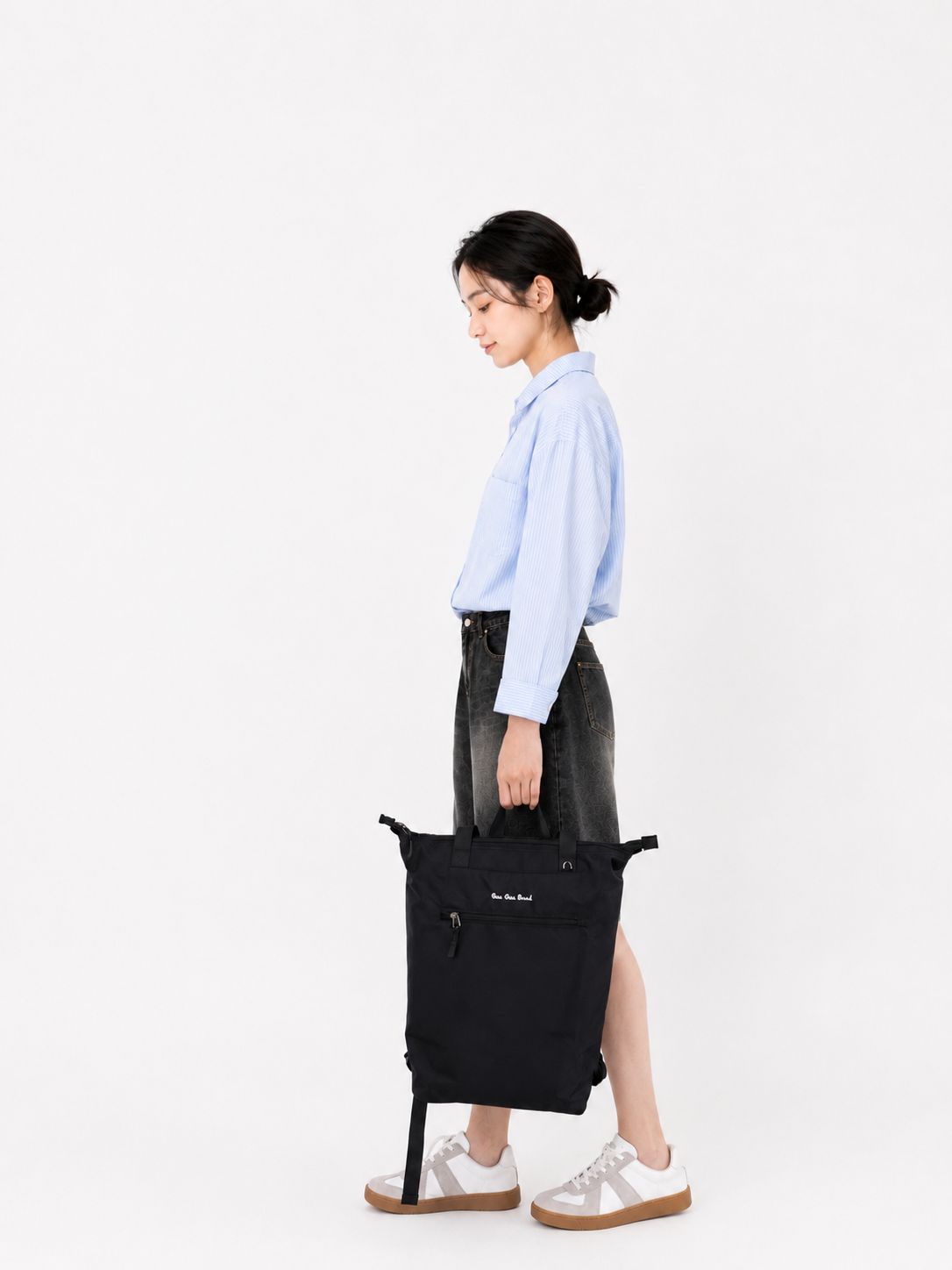 Woman carrying a carbon black laptop backpack by the top handle