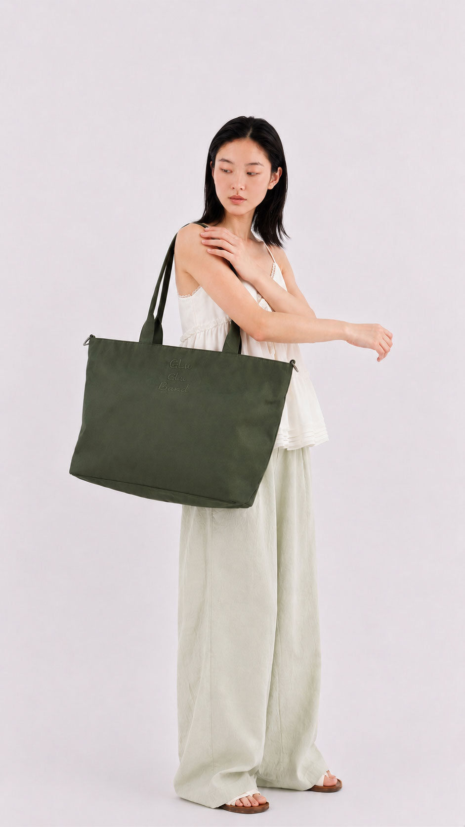 Woman wearing an olive green laptop work tote over her shoulder