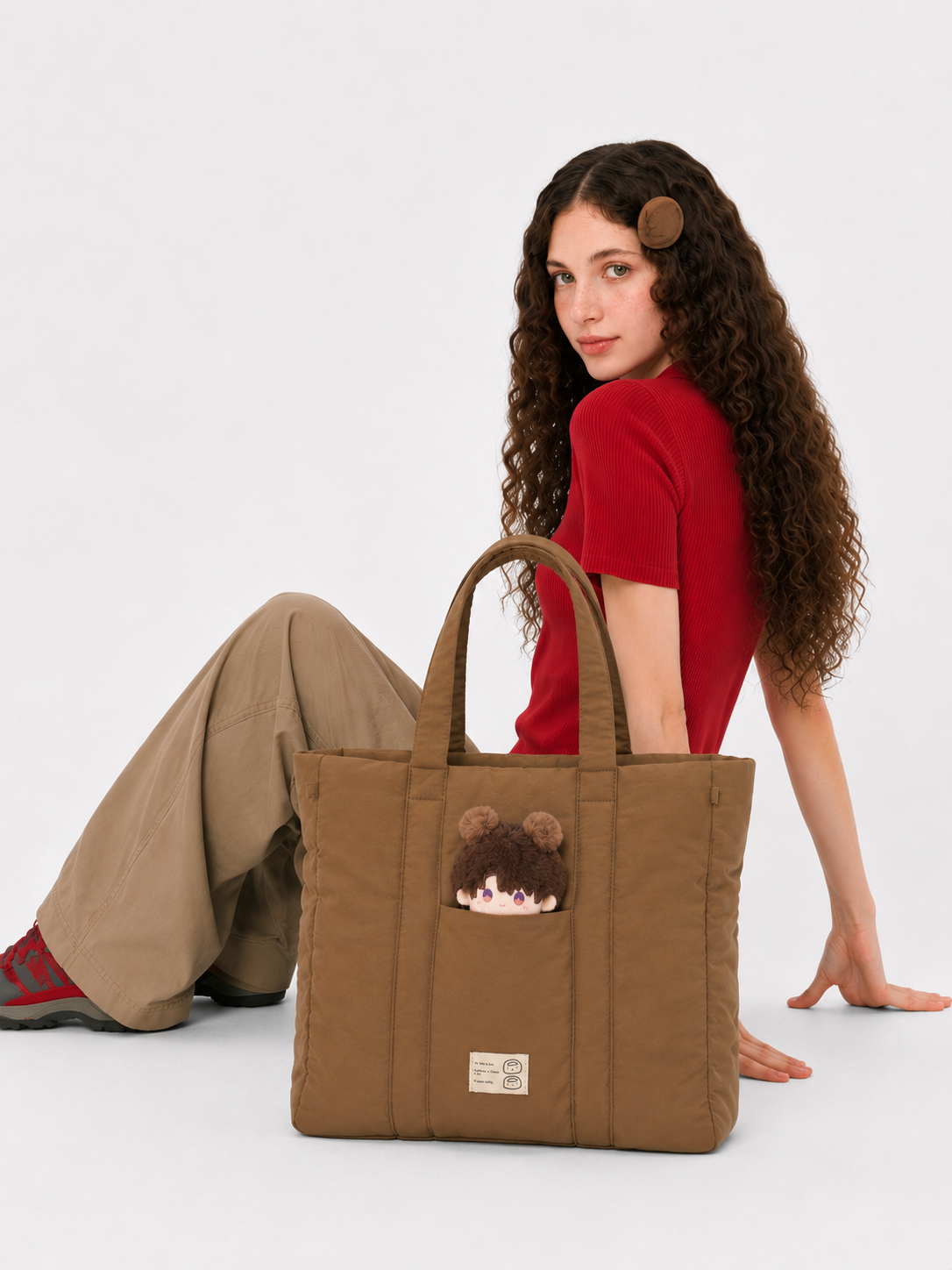 Brown 16-inch puffer laptop tote beside a seated woman