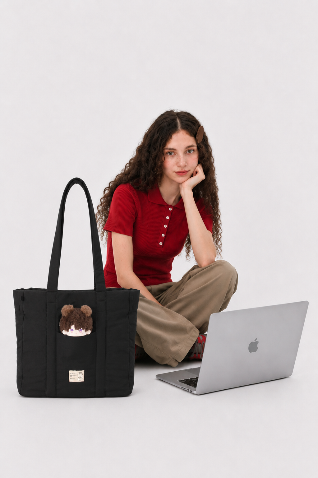 Black puffer laptop work bag beside a woman using a laptop