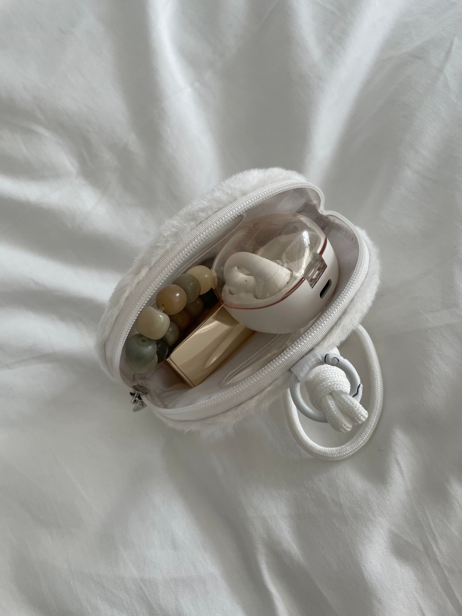 Open plush coin pouch showing its single compartment and small essentials