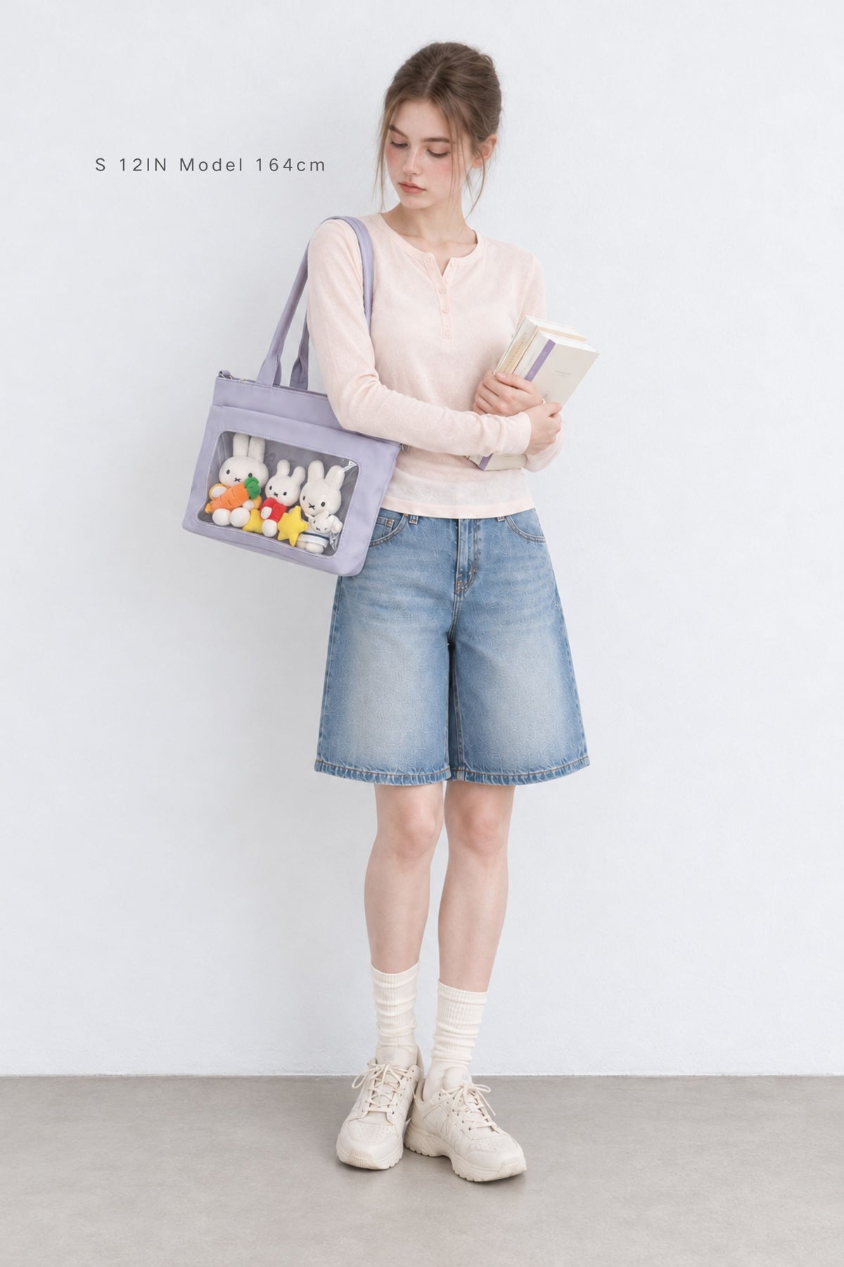 Model carrying the ita tote on her shoulder with the display pocket facing out
